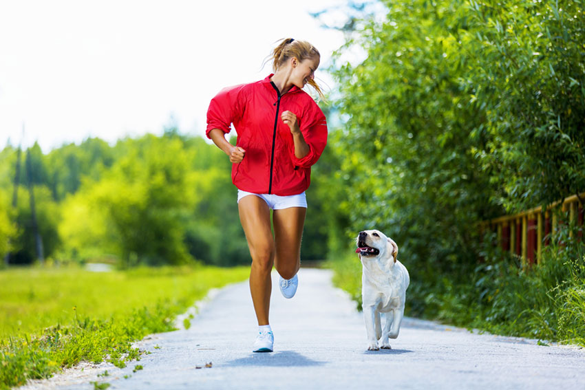 Donna che corre con cane Labrador